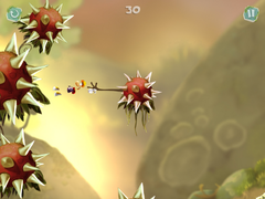 Rayman swinging towards a wall of spiky flowers.